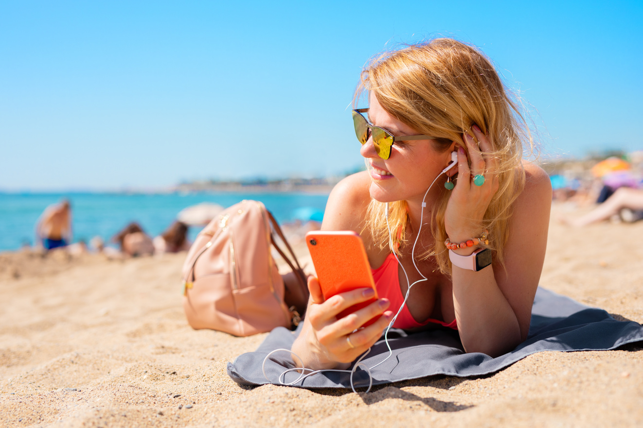 Woman Listening to Music While Relaxing on the Beach 