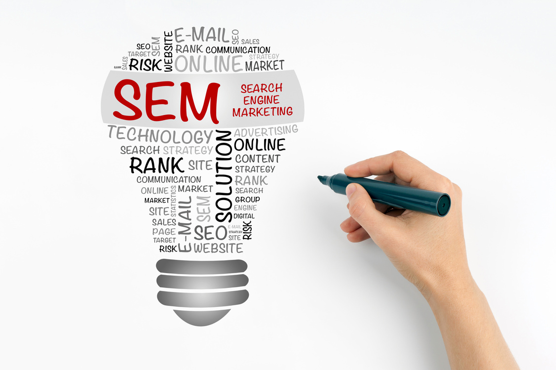 Hand with marker writing: SEM (Search Engine Marketing)